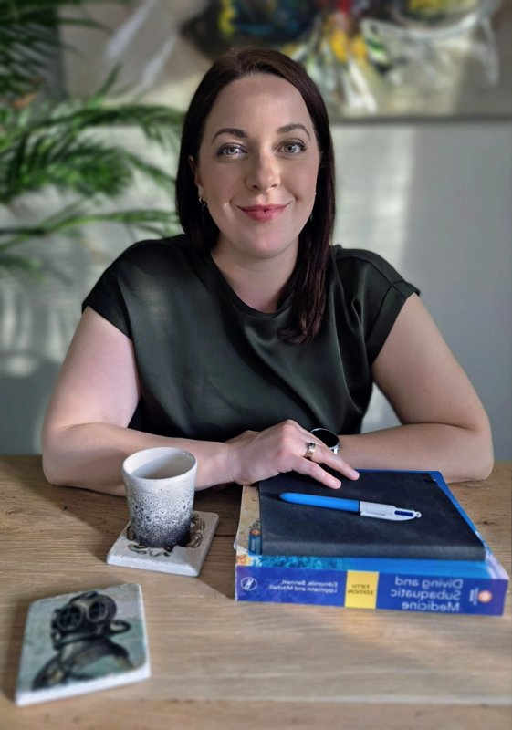 Anna Gruters-Kucal aan tafel met een boek over duikgeneeskunde Anna Gruters-Kucal aan tafel met een boek over duikgeneeskunde