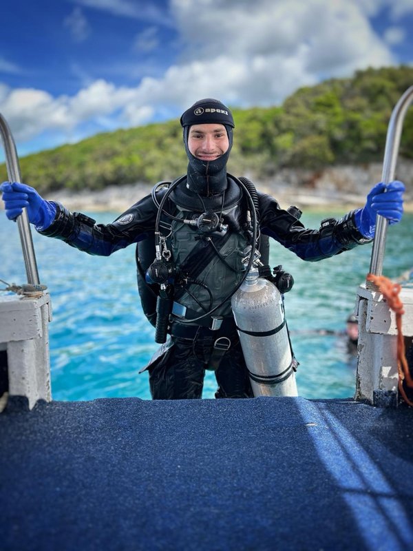 Tijmen van Kuilenburg in duikuitrusting op de trap van een boot Tijmen van Kuilenburg in duikuitrusting op de trap van een boot